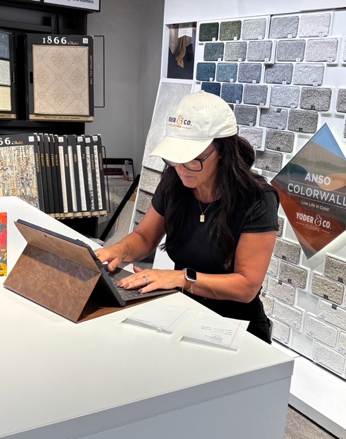 Yoder and Co flooring consultant working in the flooring showroom helping a customer choose the right floor.