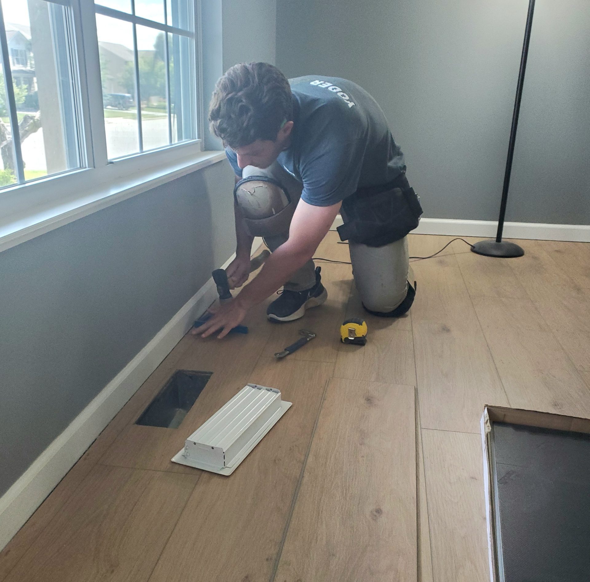 Ryan installing Yoder Flooring installer working on a hardwood installation in a home
