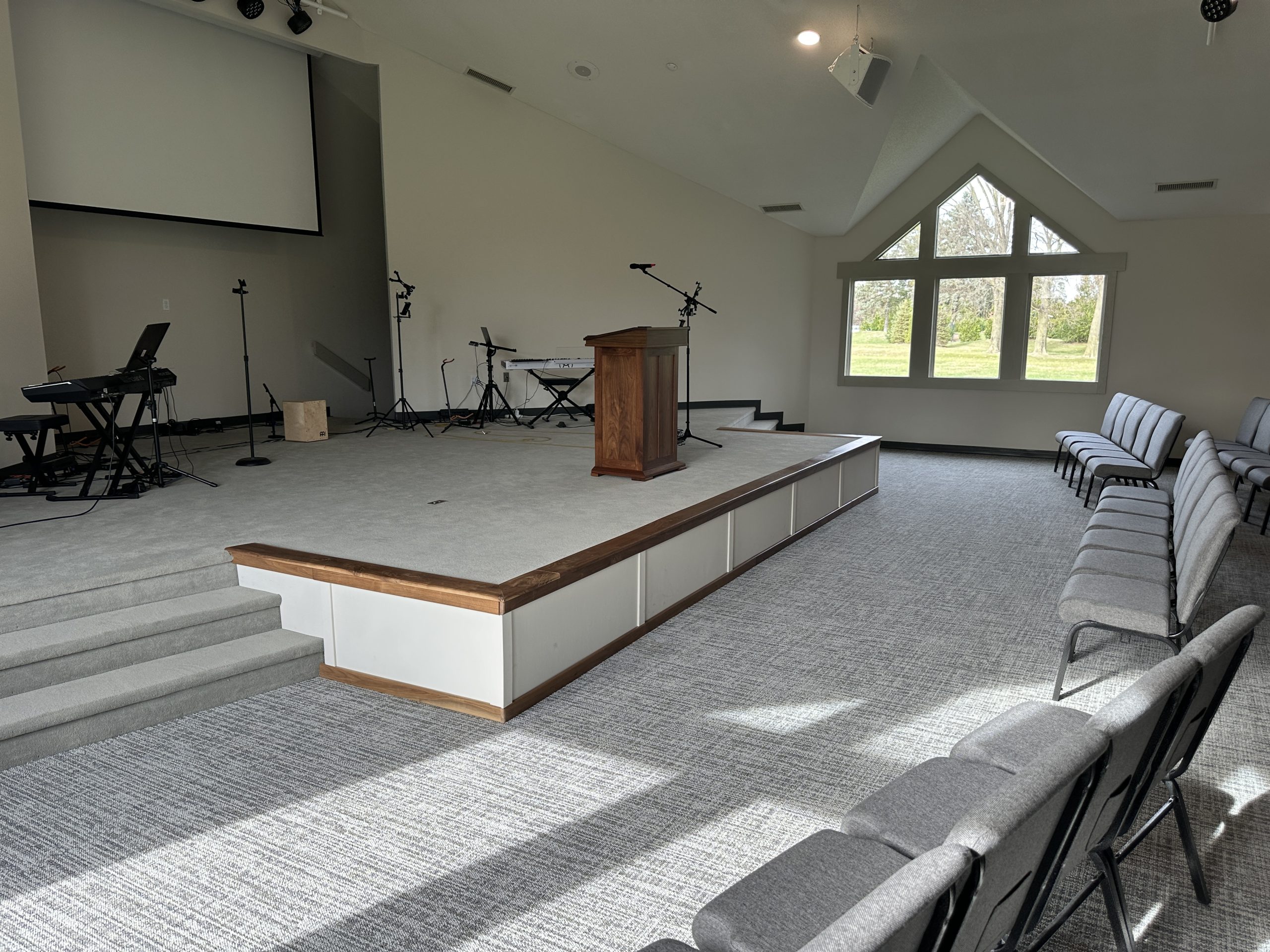 Cross-weave gray carpet tiles from Yoder Floors are installed in a church sanctuary, providing essential acoustic control and lasting durability in high-traffic spaces.