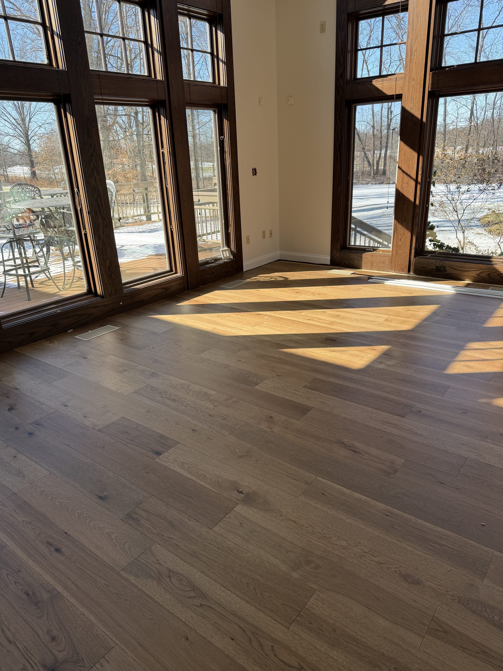 Natural light pours across the high-performance hardwood floors from Yoder Floors, highlighting the intentional grain patterns that bring a warm, residential feel to this shared community space.