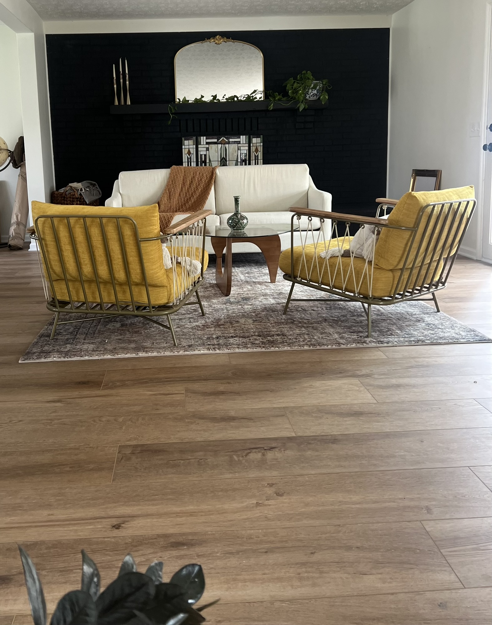 Image of a mid-century moder decorated living room with a custom patterned area rug over luxury vinyl plank flooring